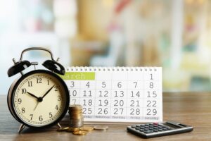 Clock along with march month calendar on the table