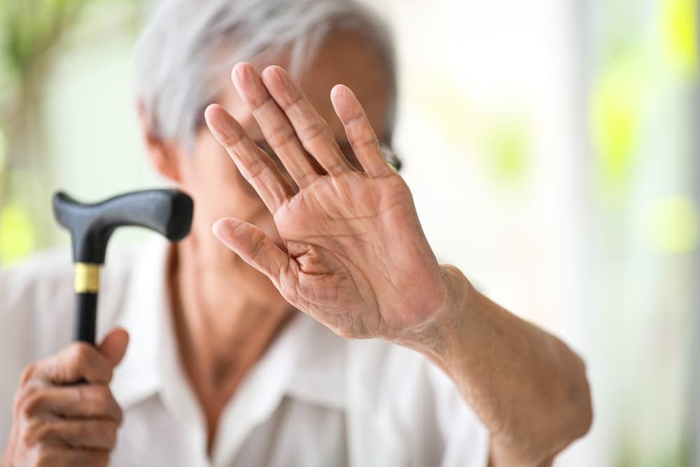 senior woman making stop gesture with palm, against Nursing Home abuse